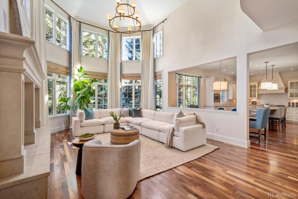 Sitting area with couches, glass windows and wooden flooring.