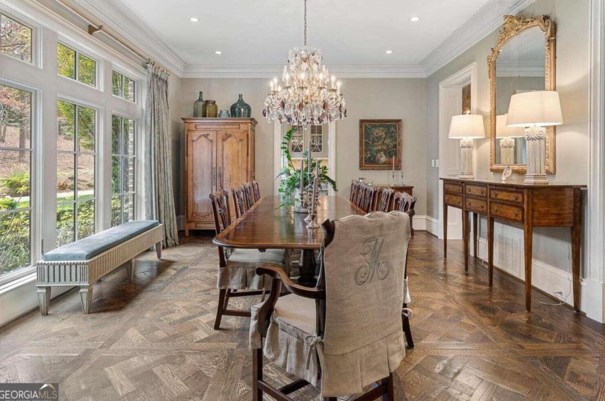 Dining room with wood flooring, custom lights and a chandelier.