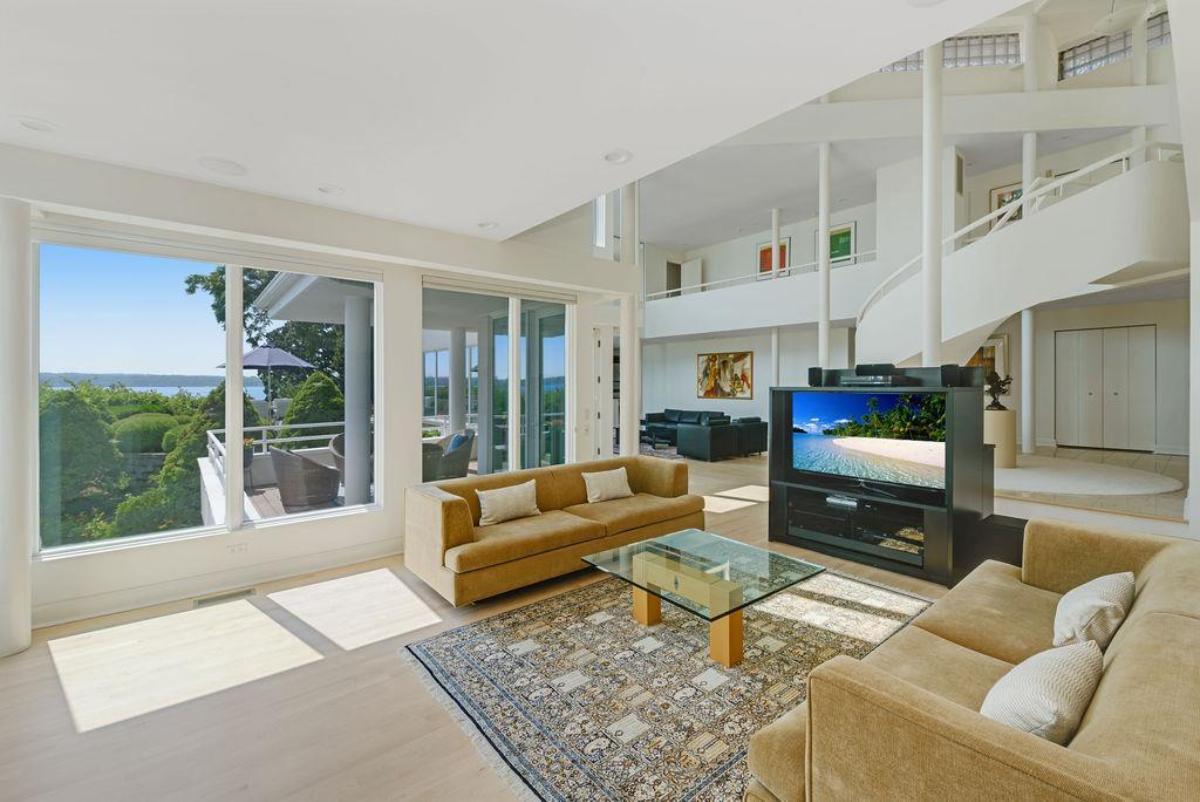 Living room with glass walls and couches.