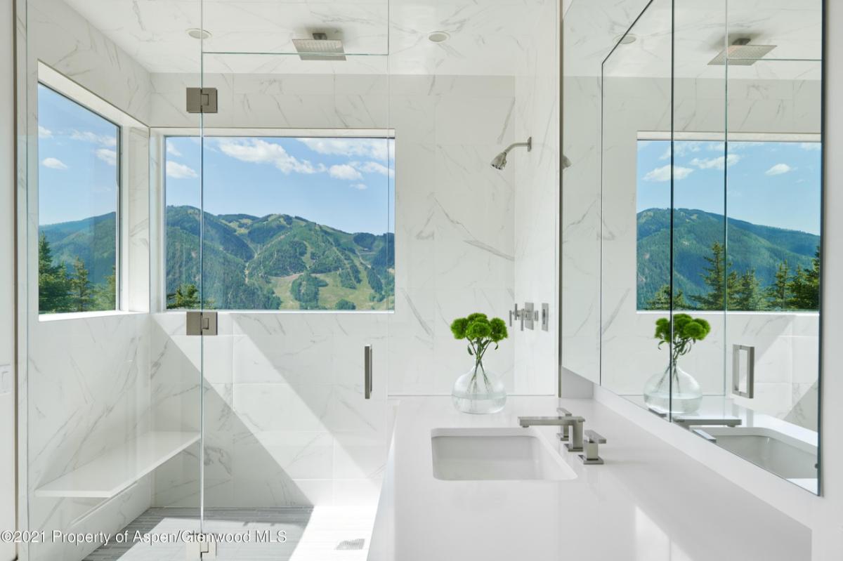 Bathroom with a sink, mirror and walk-in shower.