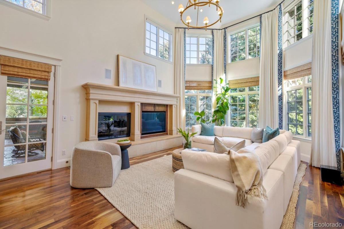 Sitting area with couches, glass windows and wooden flooring.
