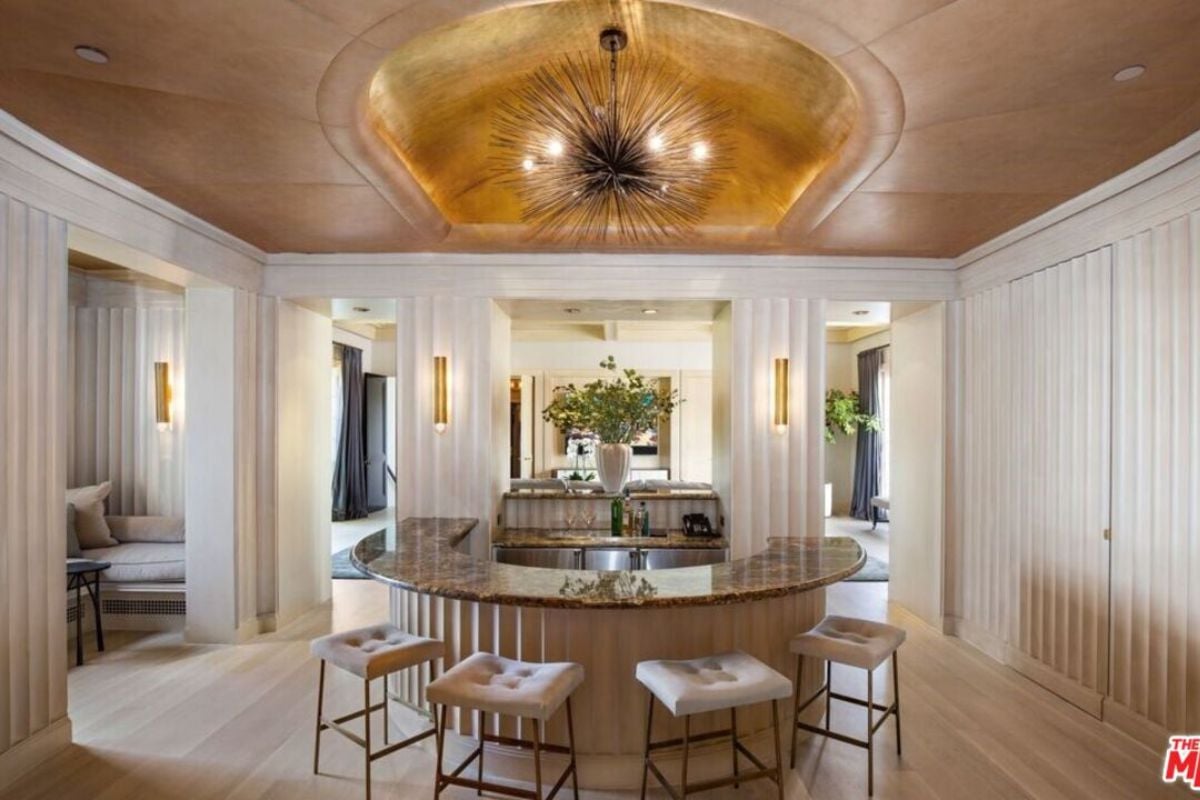 A bar with a curved counter and a chandelier.