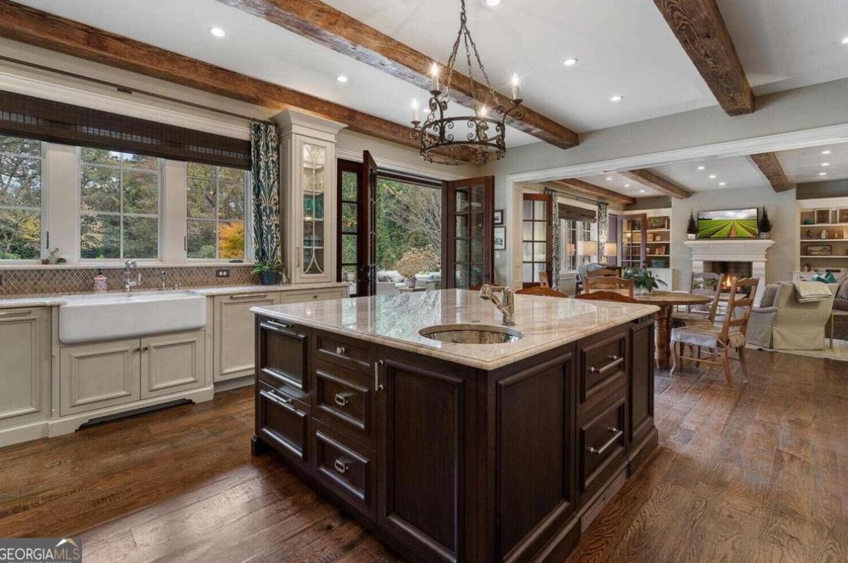 Kitchen with a large island, custom lights and open beam ceiling.