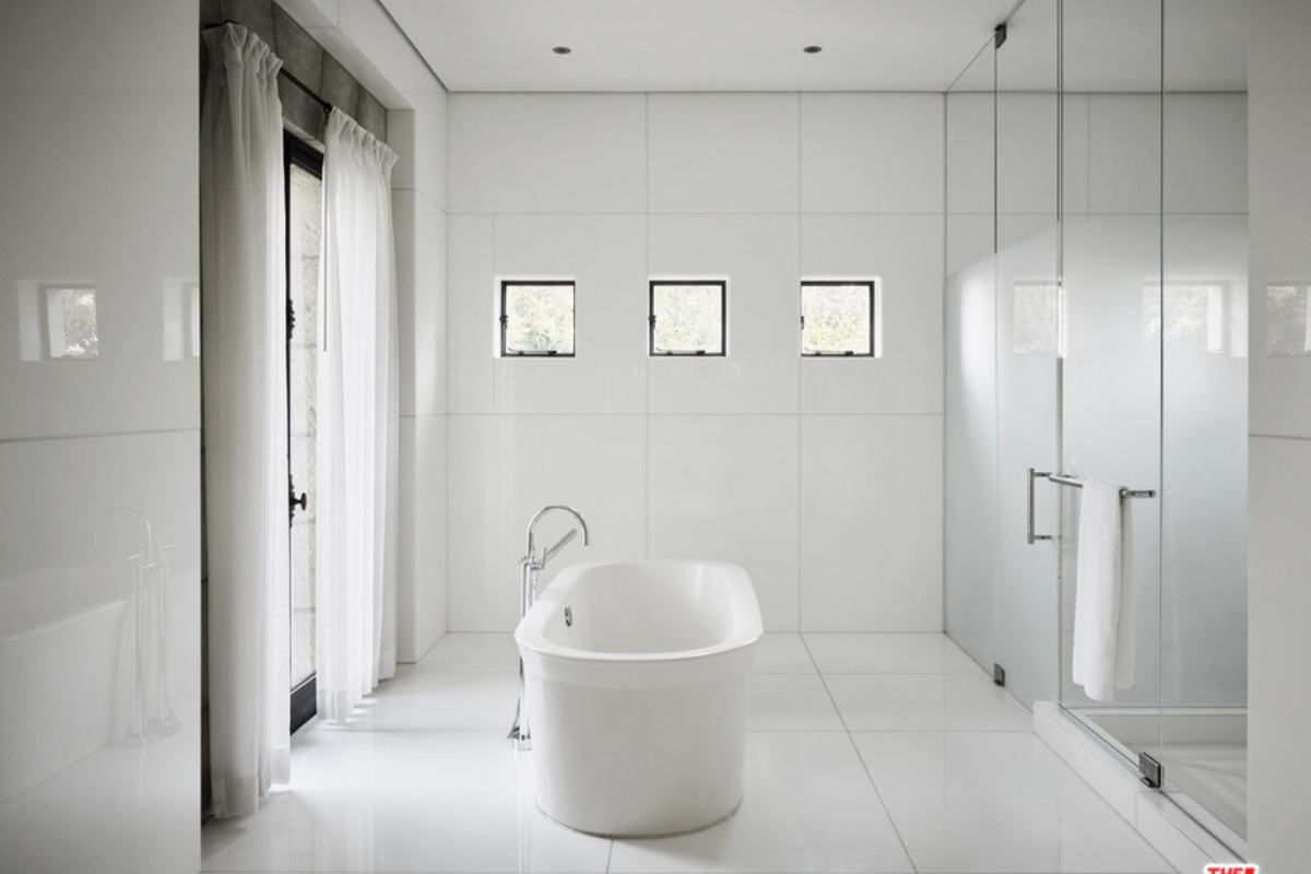 A white bathroom with a white bathtub.