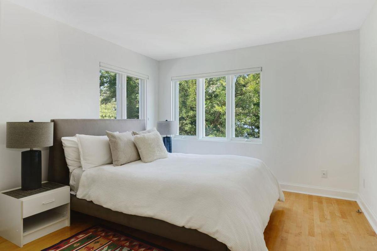 Bedroom with wood flooring and glass windows.