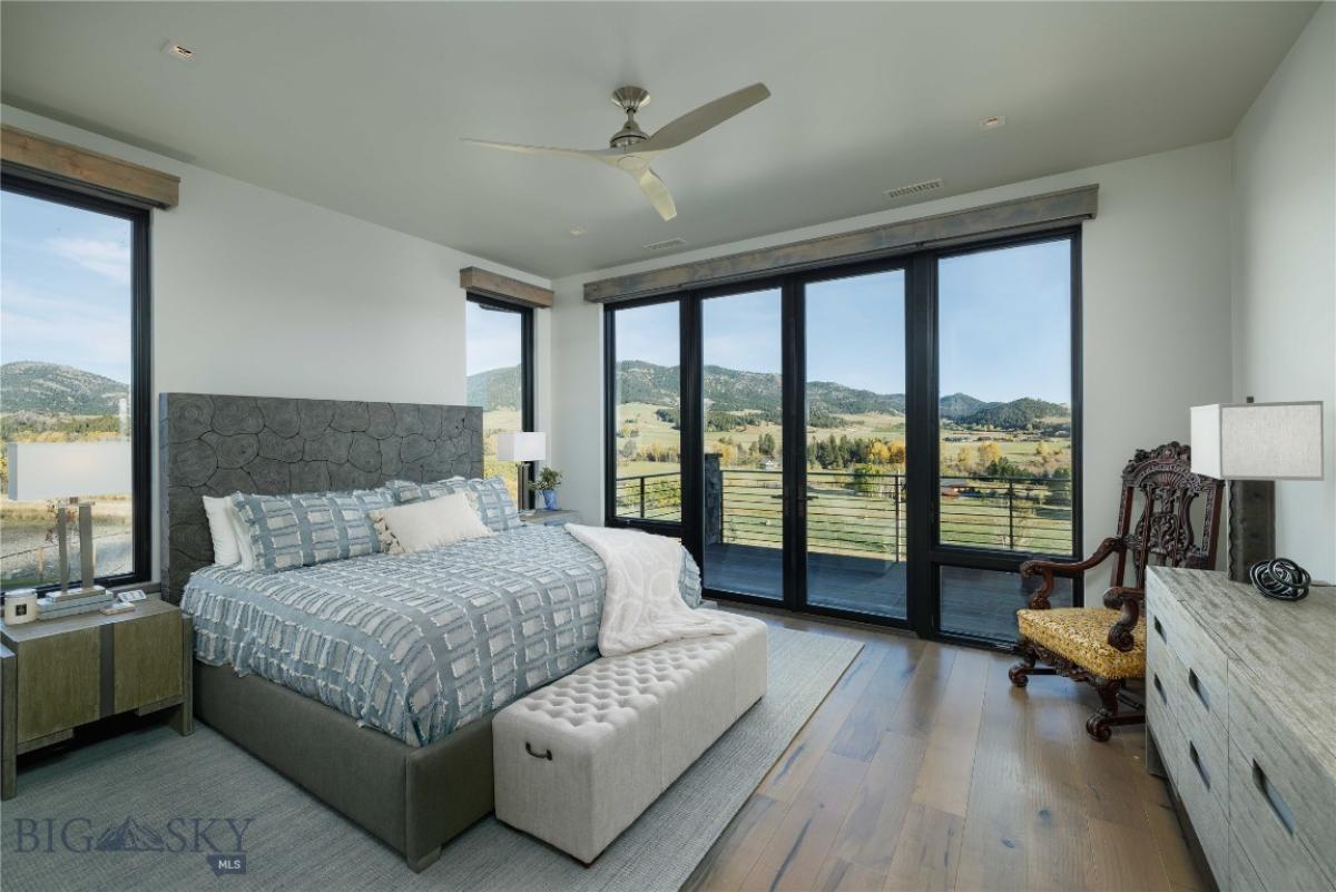 Bedroom with wood flooring and expansive sliding glass doors.