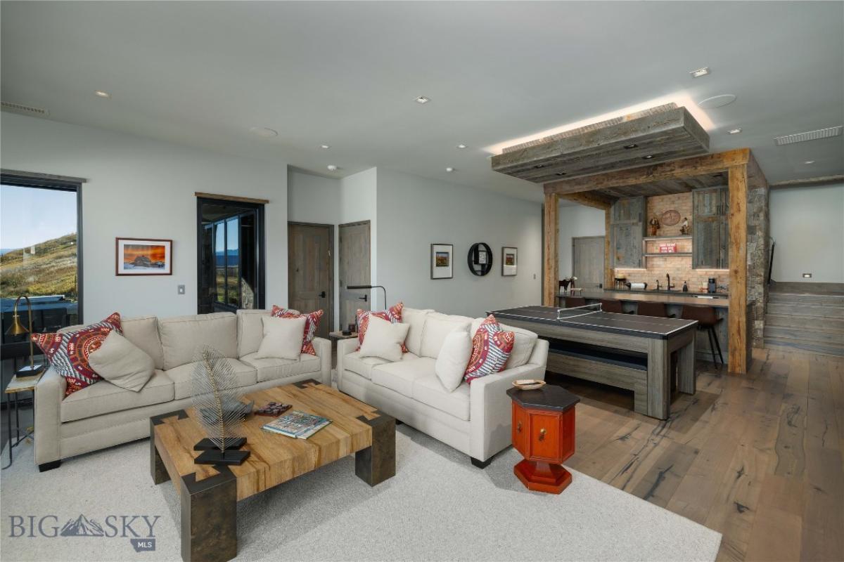 Entertainment room with couches, billiards table and a bar.