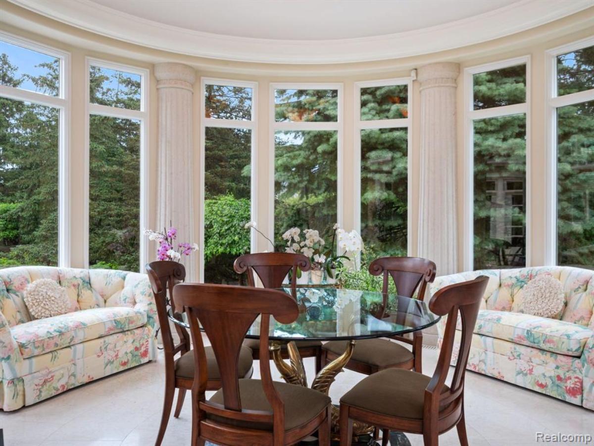 Dining area with a round glass table and chairs.