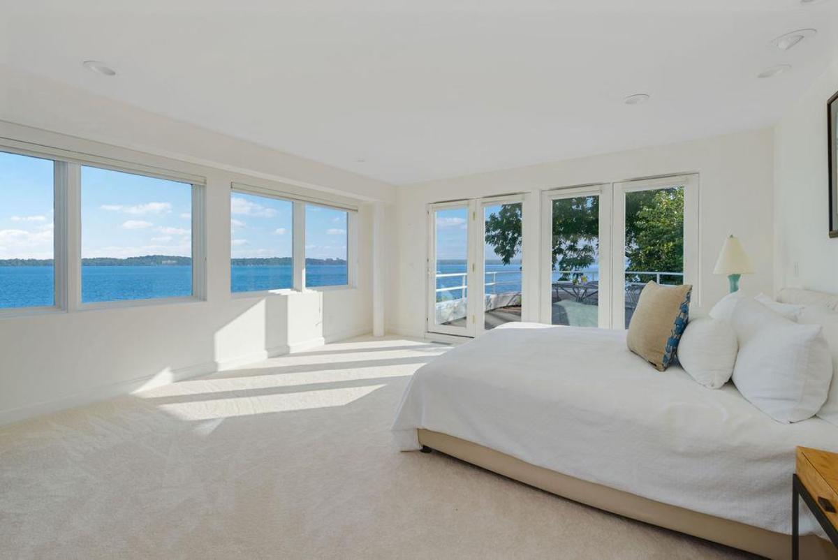 Bedroom with carpet flooring and glass windows.