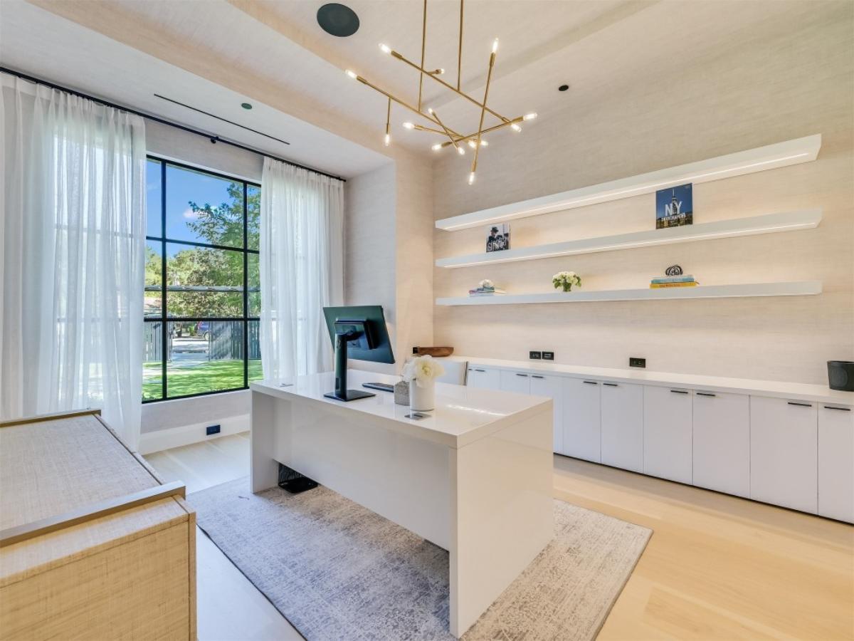 Home office with a desk, computer, couches and large rug.