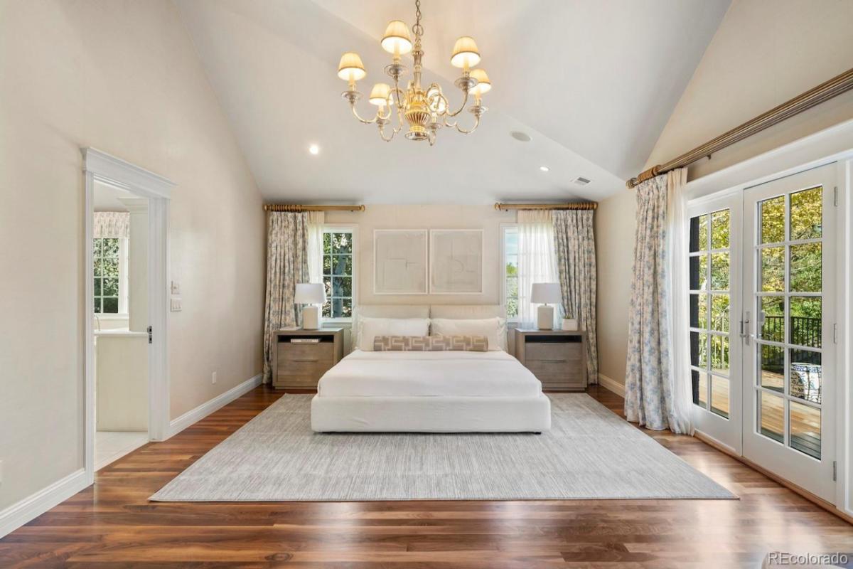 Bedroom with a large bed, large rug and glass doors.