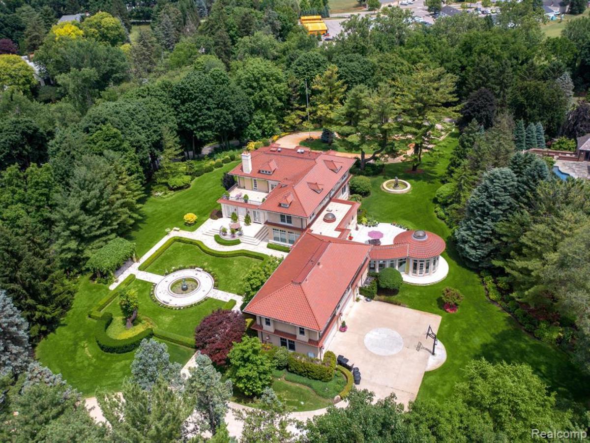 Aerial top view of the mansion surrounded by trees.