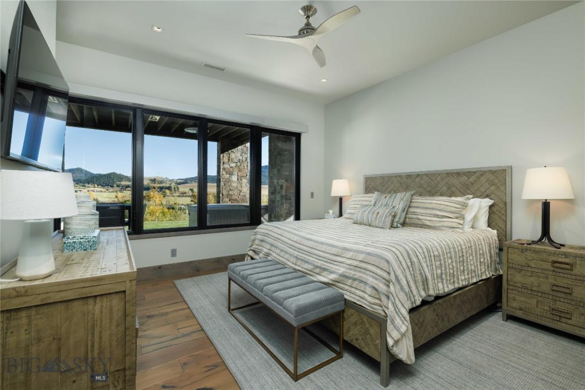 Bedroom with wood flooring and glass windows.