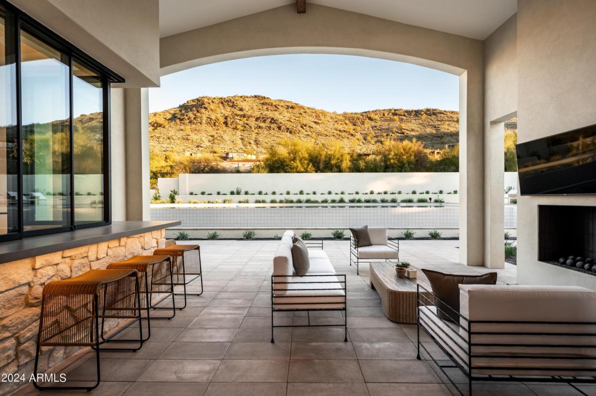 Patio with a fireplace and chairs.