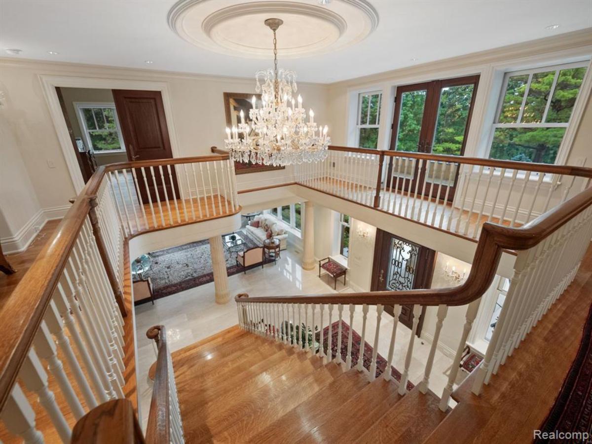 Staircase with glass windows and a chandelier.