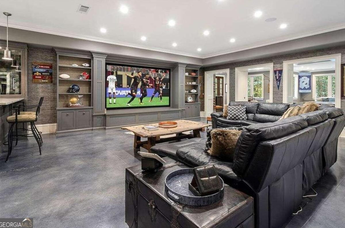Recreational room with a large TV and couches.