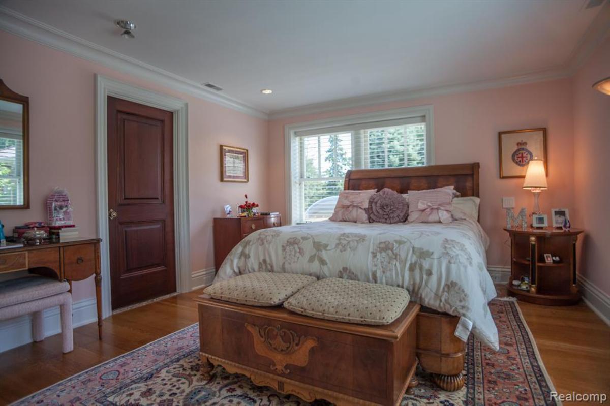 Bedroom with a large bed, glass windows and a large rug.