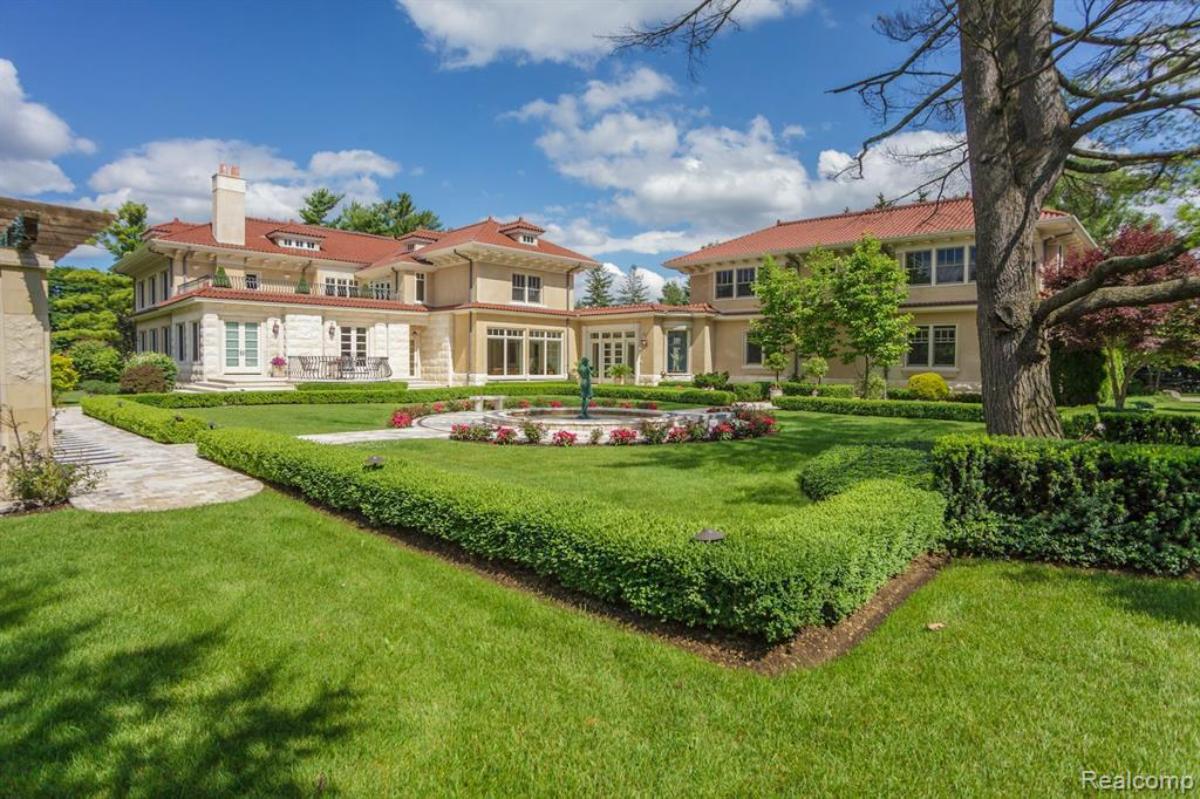 Backyard of the mansion with a large green lawn.