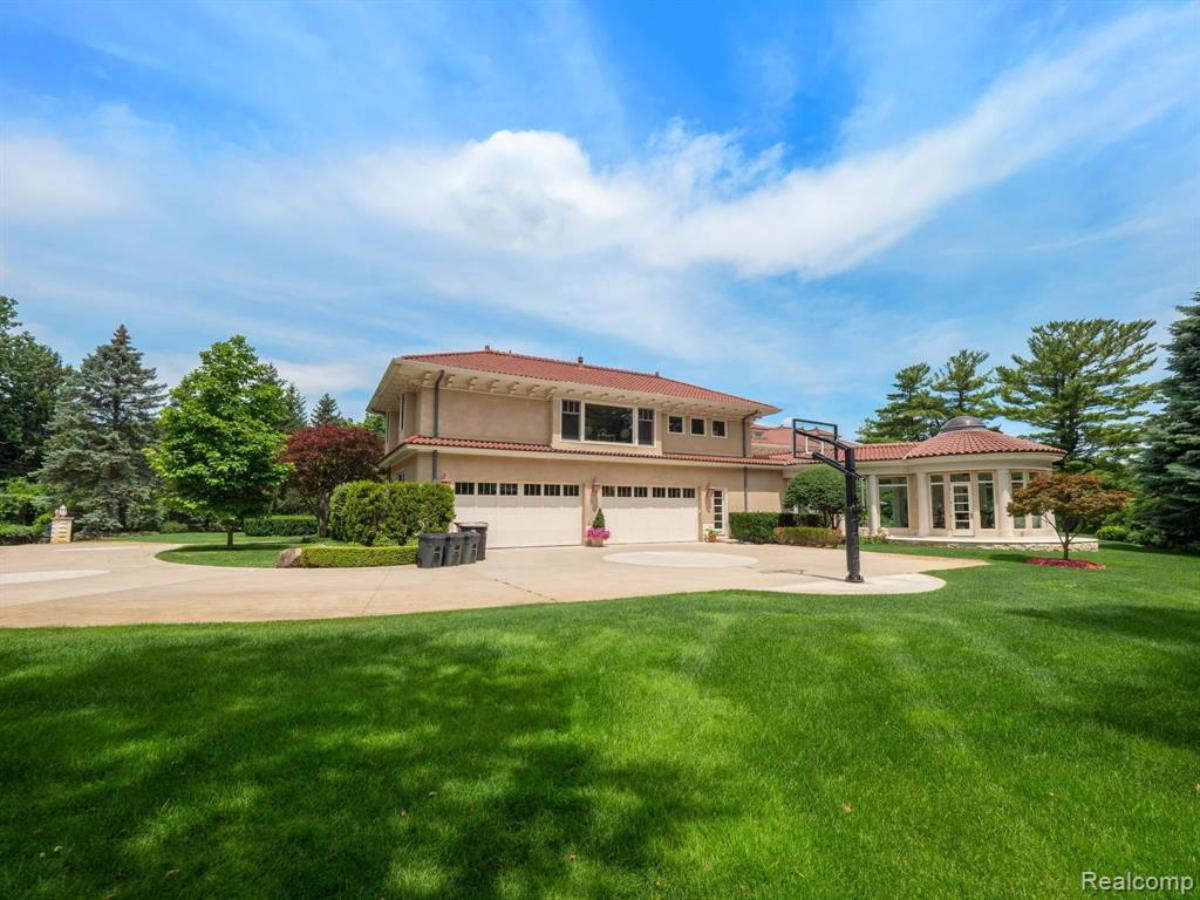 Exterior view of the mansion with garage and basketball court.
