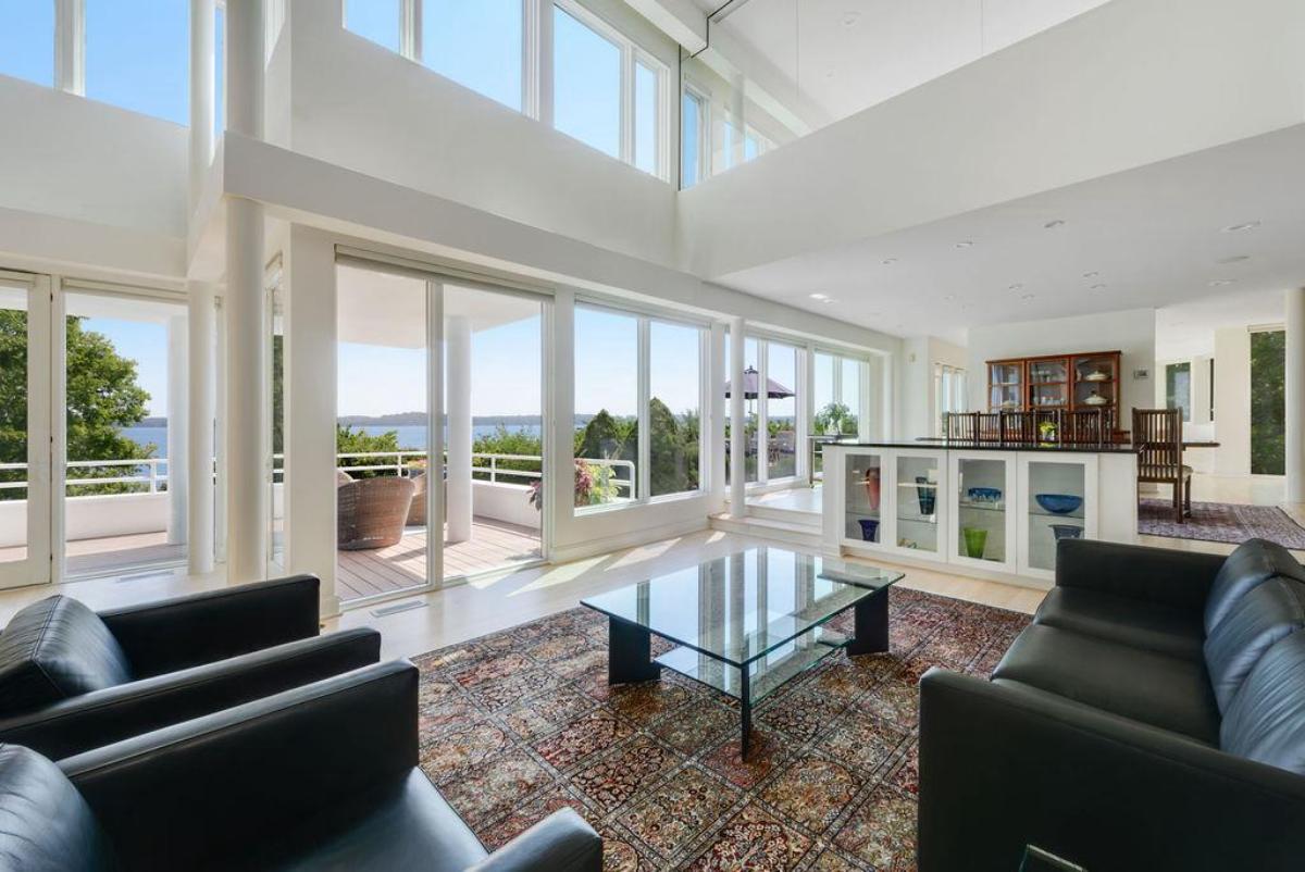 Living room with couches and glass walls.