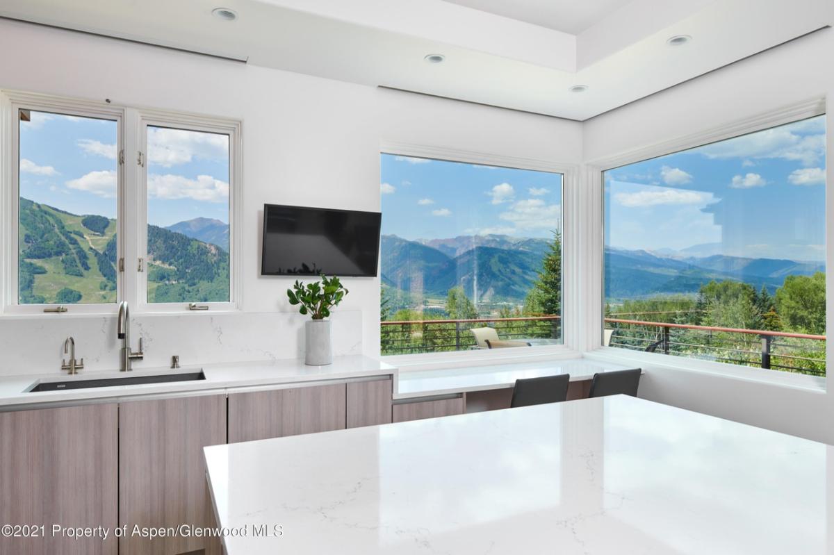 Kitchen with a large window overlooking the mountains.