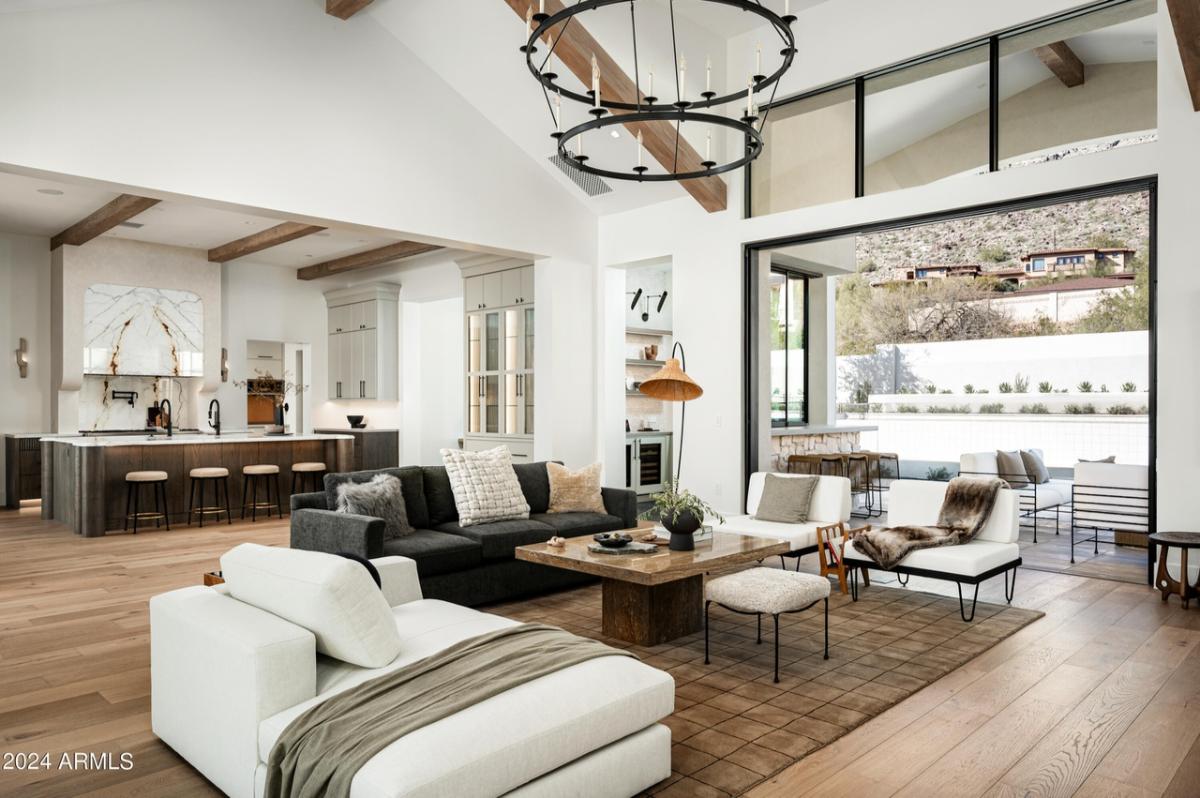 Living room with a couch, wooden floor and a large rug.