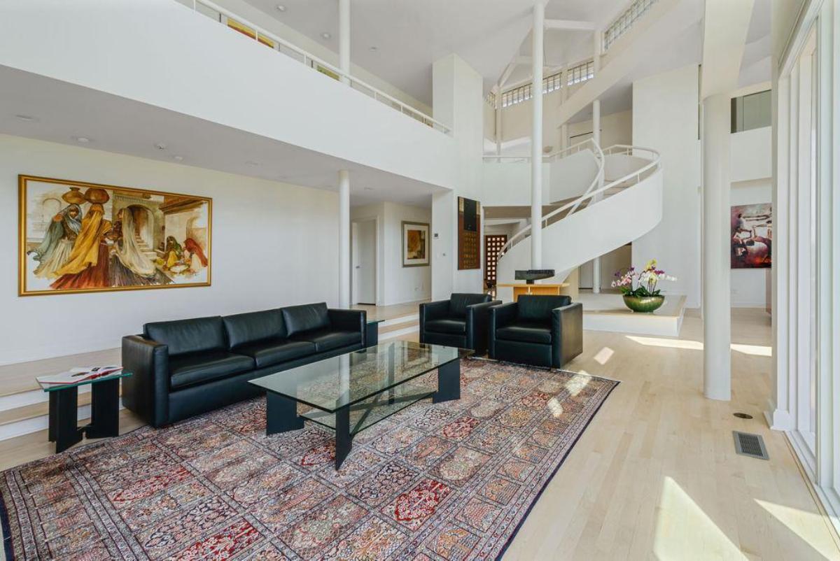 Living room with couches and wood flooring.