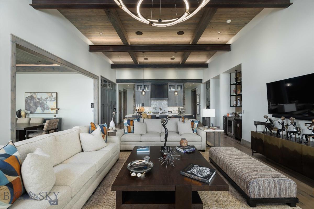 Living room with open beam ceiling and custom lights.