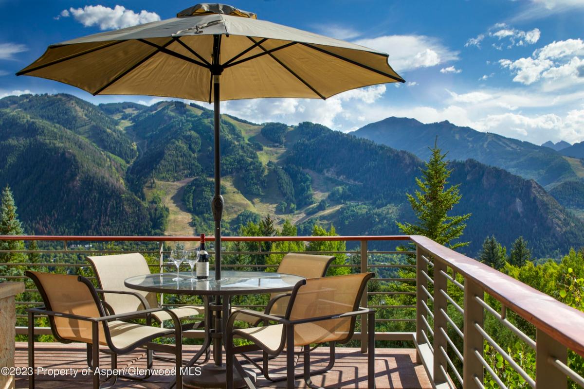 Terrace with a table, chairs and a view of the mountains.