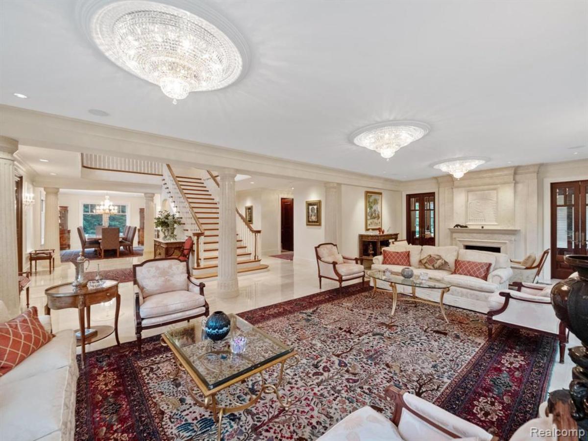 Living room with a couch, staircase and a large rug.