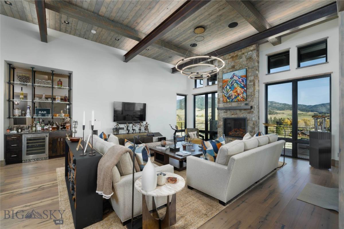 Living room with open beam ceiling, fireplace and custom lights.