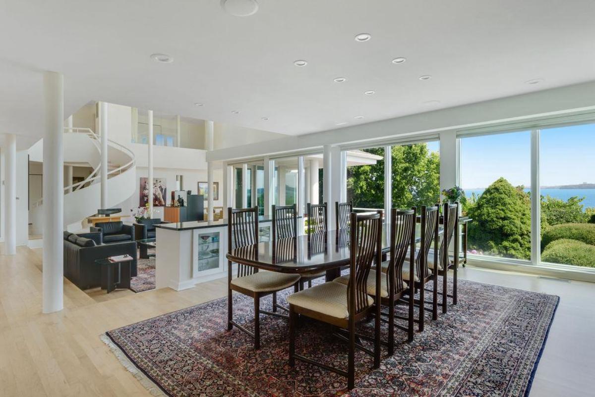 Dining room with wood flooring and glass walls.