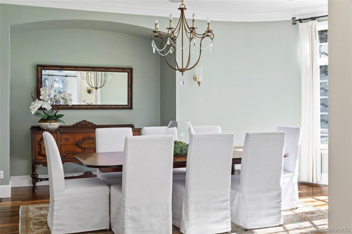 Dining room with a large table, chairs, and a large rug.