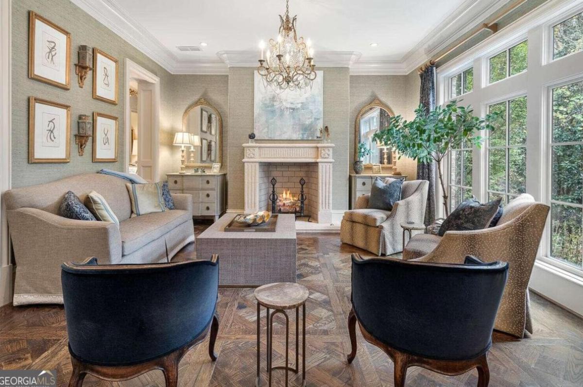 Living room with couches, chandelier and a fireplace.