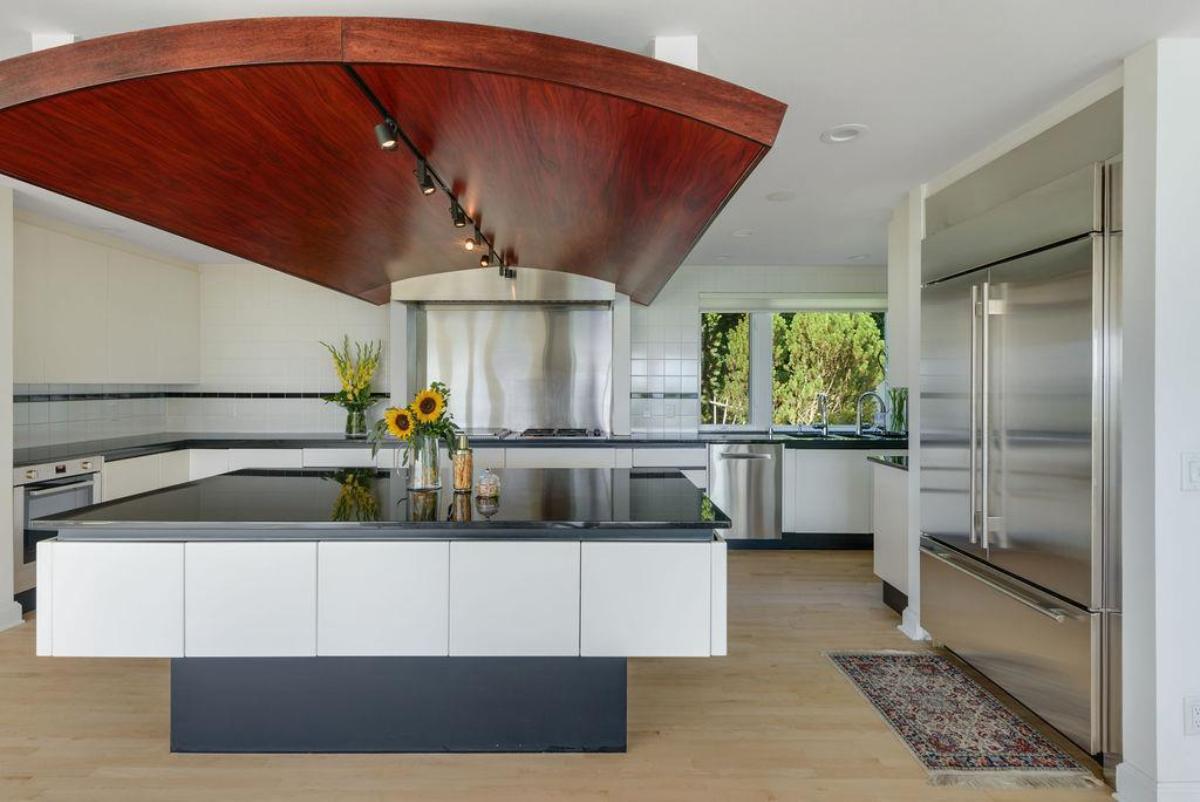 Kitchen with a large island, custom lights and high-end appliances.
