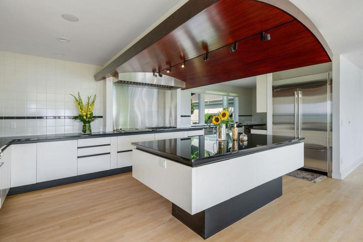 Kitchen with a large island, custom lights and high-end appliances.