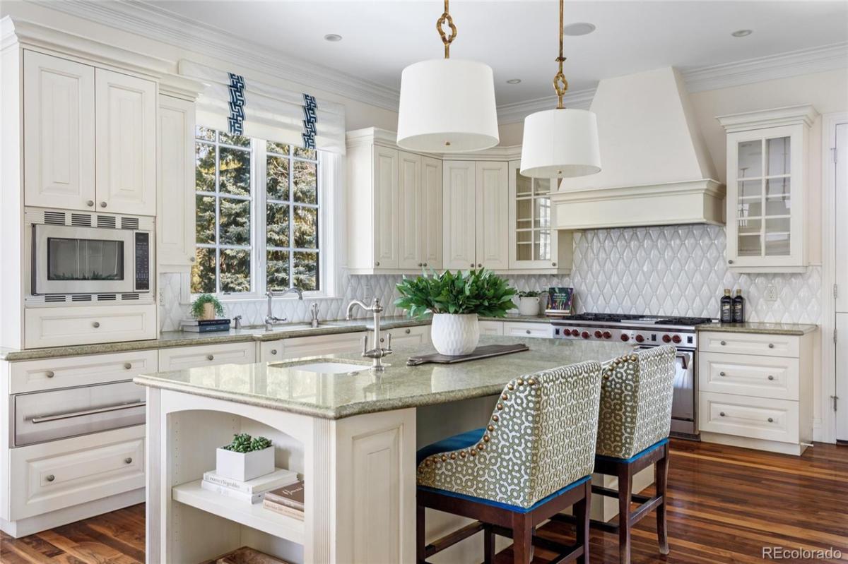 Kitchen with a large island, glass windows and a stove.