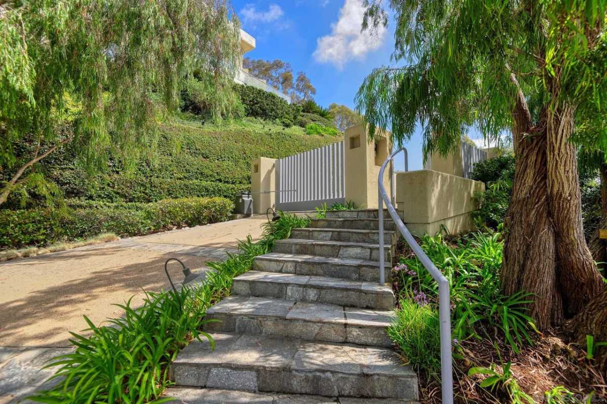 An outdoor stone staircase with a metal handrail.