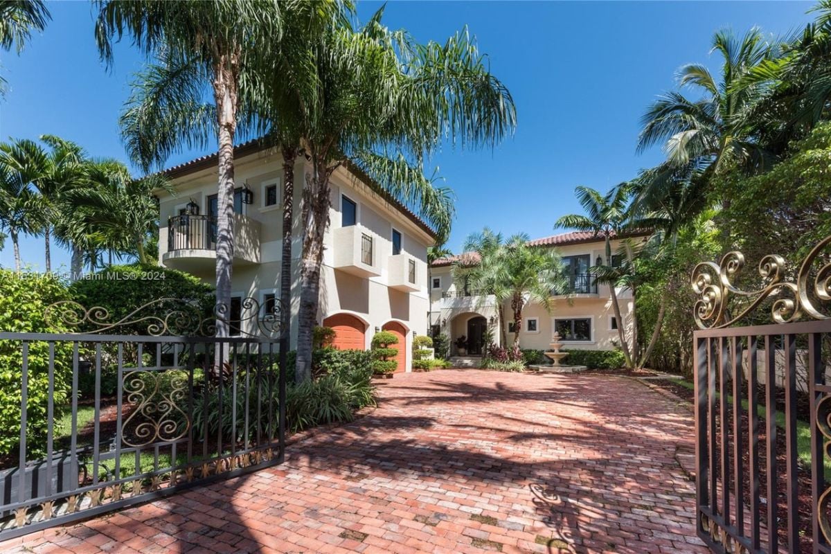 A brick courtyard adorned with trees, plants, and a fountain.