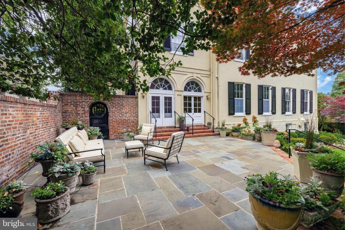 A patio with a couch, center table, and chairs.