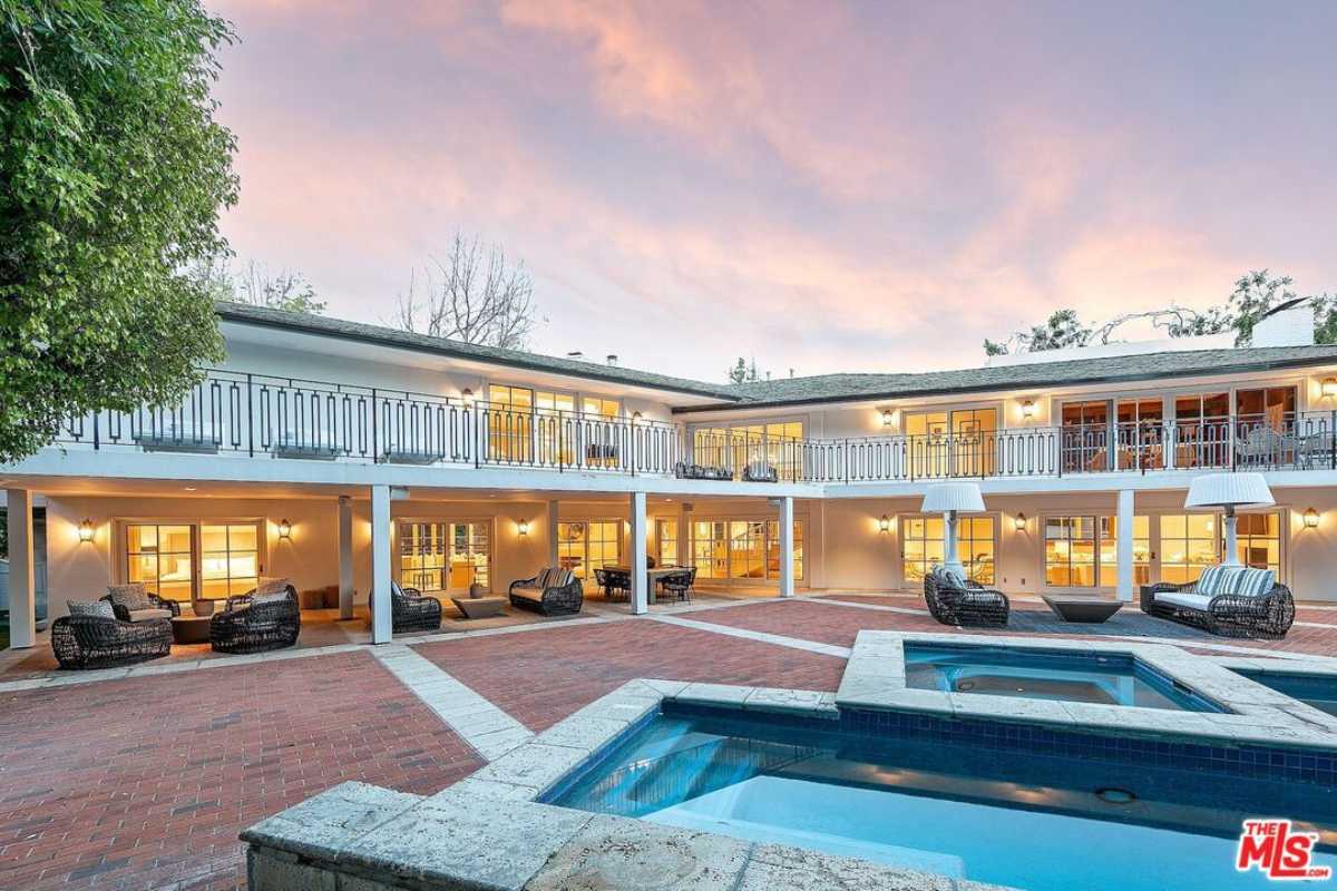 A brick courtyard featuring a pool and chairs.