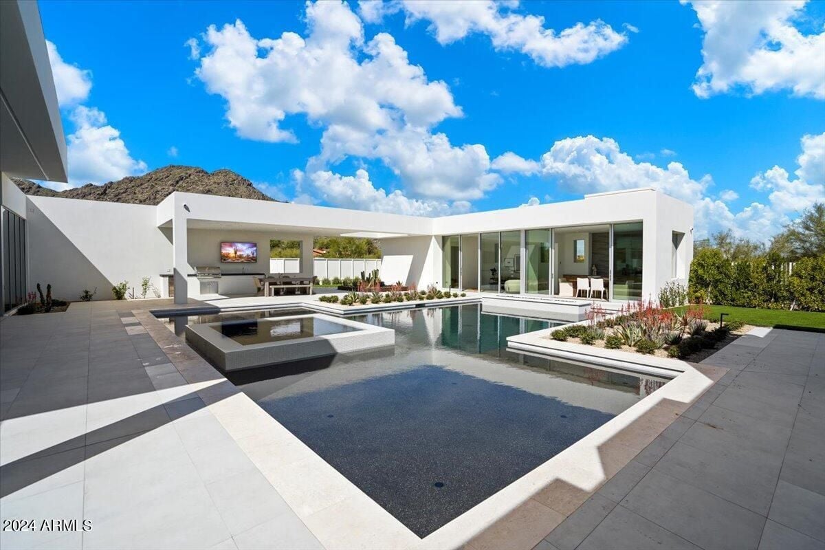 A swimming pool with a jacuzzi and plants.