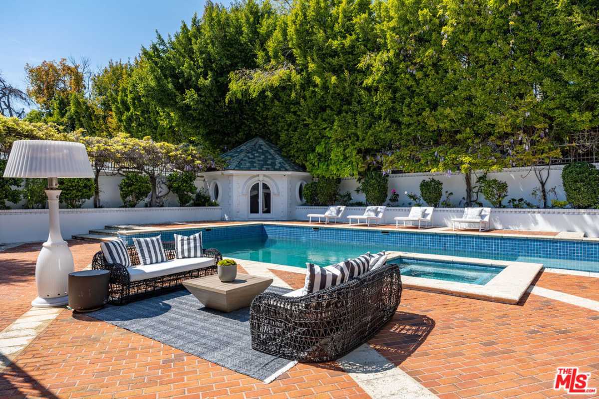 A patio furnished with a rug, couches, and a coffee table.