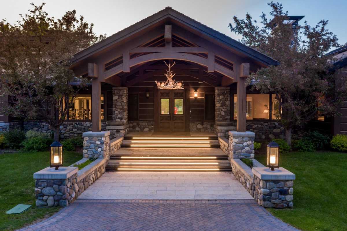 A front entry featuring stairs, a chandelier, and a wooden door.