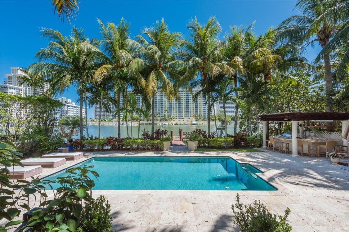 A swimming pool nestled among trees and plants.
