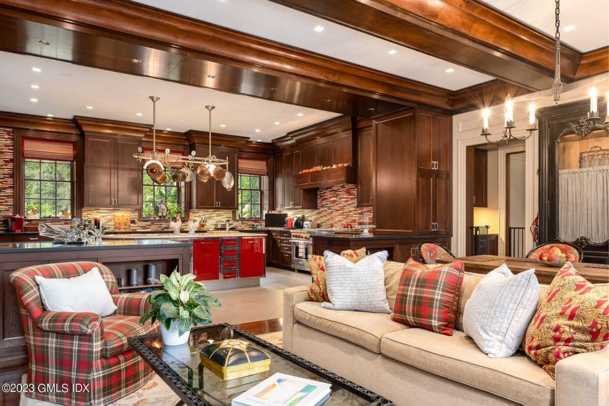 A great room with a beamed ceiling, living space, kitchen, and dining area.