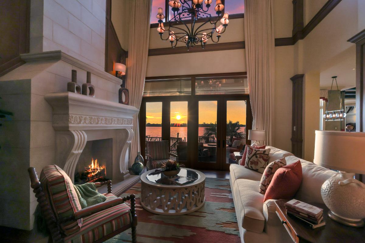 Living room with a couch, glass doors, fireplace and a large rug.