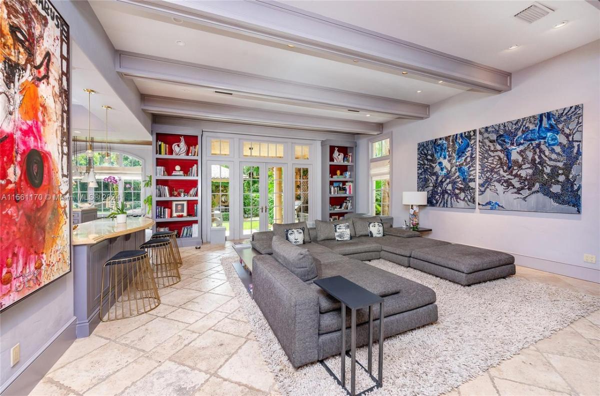 Living room with couches, open beam ceiling and custom lights.