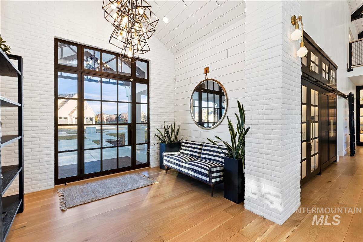 Sitting area with chairs, glass doors and a chandelier.