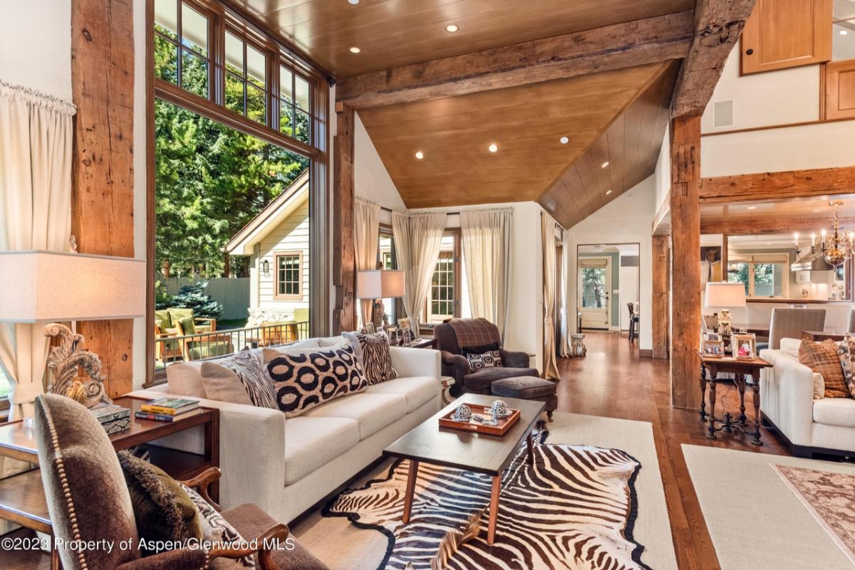 Living room with a couch, glass window and a large rug.
